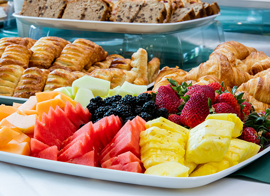 Assortment of pastries and fruits on buffet-style table