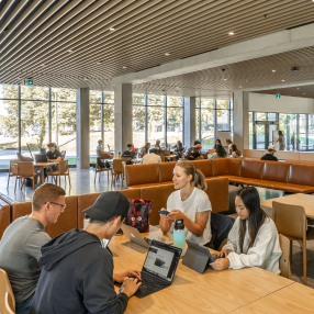 People sitting at a table with laptops